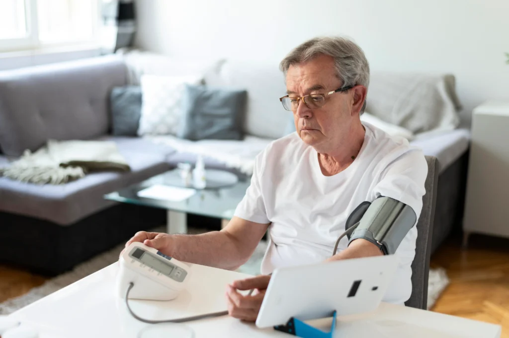 Una persona tomándose la tensión arterial con un tensiómetro digital.